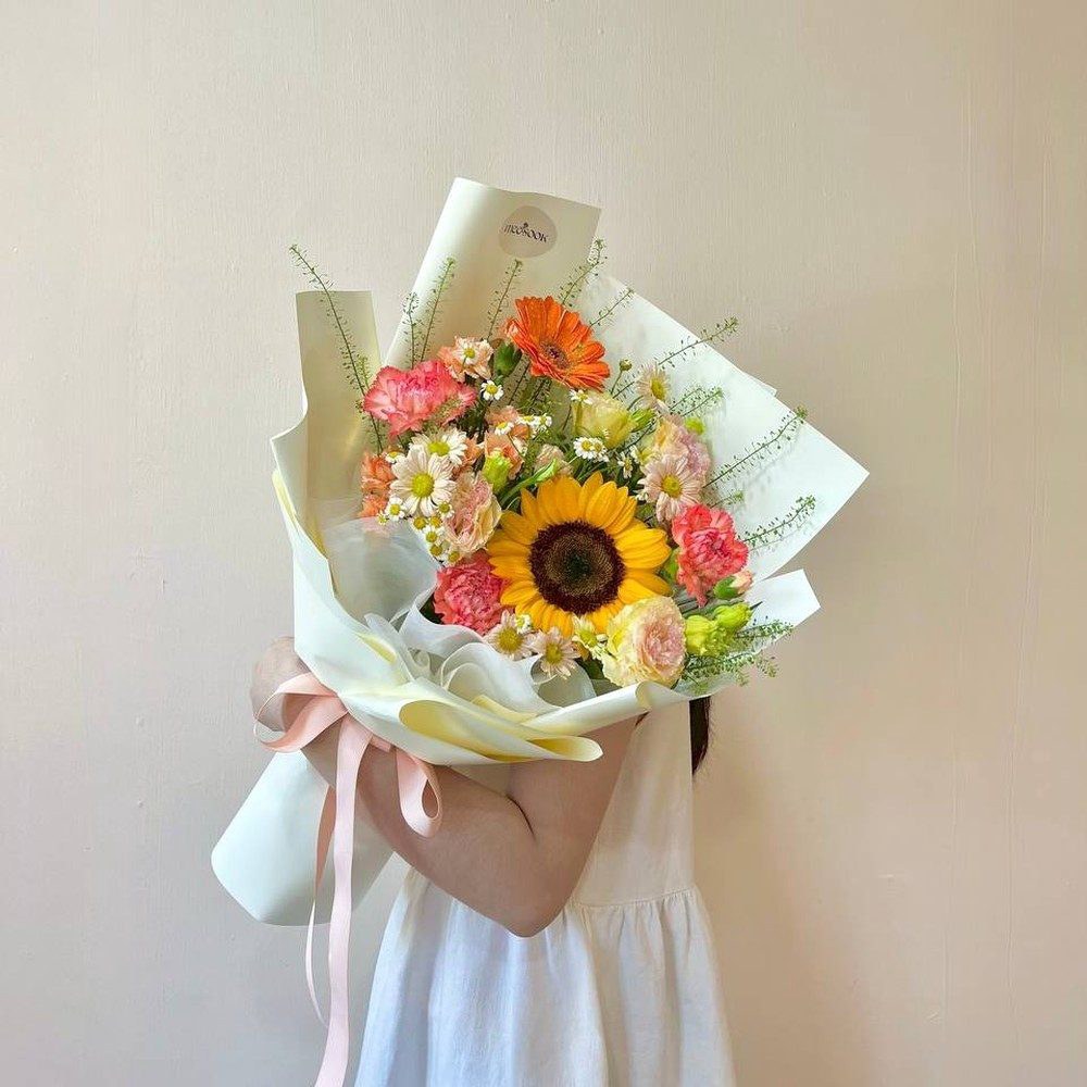 ช่อดอกไม้โทนเหลืองส้ม ห่อกระดาษสีครีม ผูกริบบิ้นสีพีช