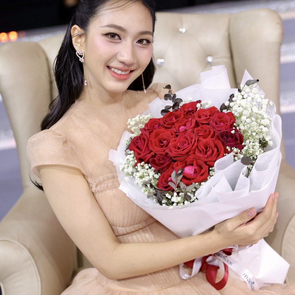 ช่อดอกไม้ Crimson Snow ในอ้อมกอด มองเห็นดอกแดงซ้อนกลีบและดอกเล็กสีขาว